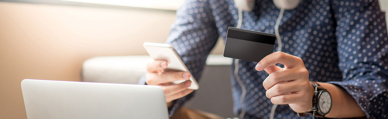 Man looking at his phone and his credit card.